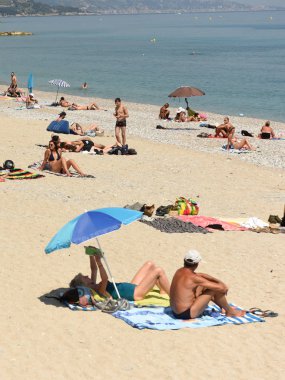 Menton, Fransa - 18 Haziran 2019: Fransız Rivierası'nın Cote d'Azur'undaki Menton sahilinde insanlar dinleniyor.