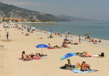 Menton, Fransa - 18 Haziran 2019: Fransız Rivierası'nın Cote d'Azur'undaki Menton sahilinde insanlar dinleniyor.