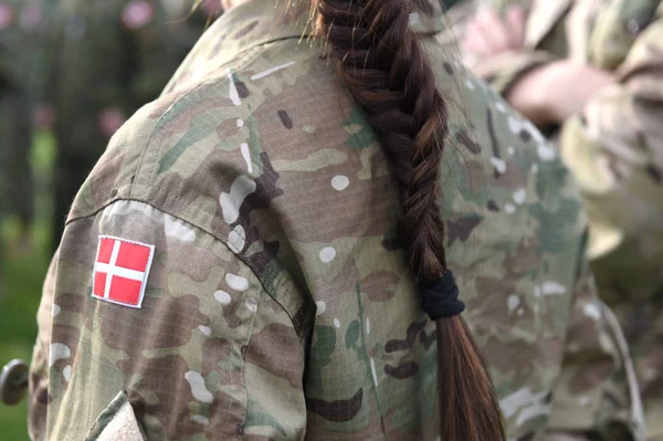 Woman soldier. Woman in army. Flag of Denmark on soldiers arm.