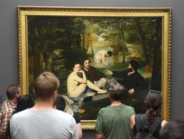 Paris'teki Museum d'Orsay'da Edouard Manet tablosundan Le dejeuner sur l'herbe yakınlarındaki ziyaretçi.