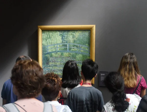 Натовп відвідувачів біля води-Лілія ставок, Симфонія в зелений 1899 Клода Моне живопису в музеї Орсе в Парижі, Франція. — стокове фото