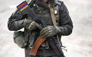 Flag of Armenia on submachine gun butt. Military Conflict in the Caucasus. Collage. 