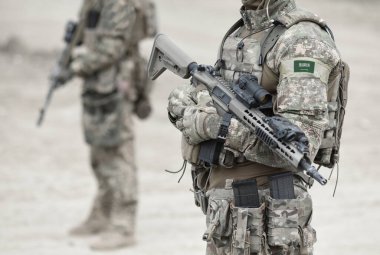 Askeri üniformalı Suudi Arabistan bayrağı ve makineli tüfekli askerler. Kolaj. 