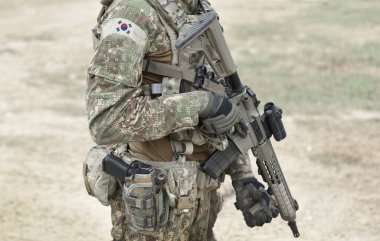 Soldier with assault rifle and flag of South Korea on military uniform. Collage.  clipart