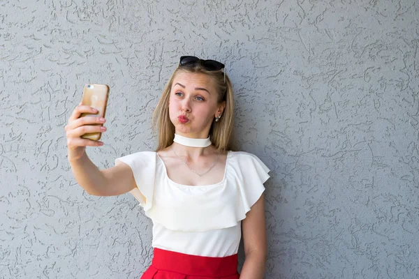 Rolig blondin poserar med smartphone — Stockfoto