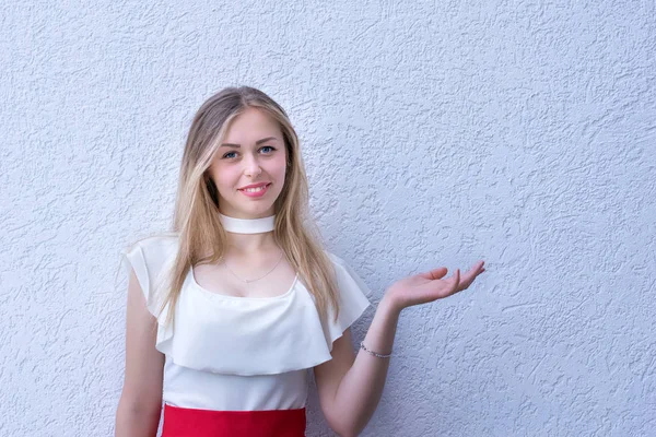 Vrij lachende meisje op een gestructureerde achtergrond wijzend op smth. — Stockfoto