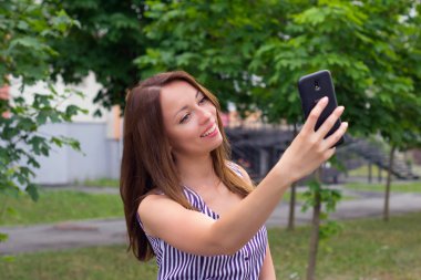 Mutlu esmer açık havada telefon ile poz