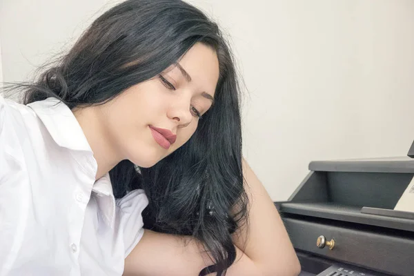 Mujer sentada cerca de un piano y soñando — Foto de Stock