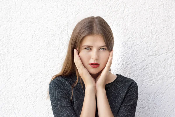 Genç kadın modeli etkileyici doğal makyaj ile kameraya bakarak portresi. Yüz eller güzel kadın açık havada tutan poz. Beyaz arka plan üzerinde izole