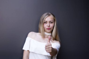 Sarışın başparmak tabela yapım ve neşeyle, ona gösterilen gülümseyen desteklemek ve birine saygı