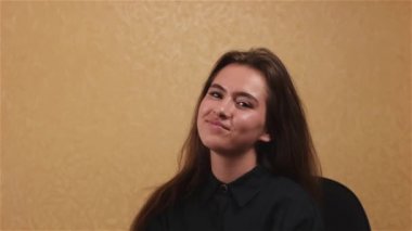 Siyah elbiseli kamera ofiste bakarak uzun kahverengi saçlı güzel gülümseyen genç kadın