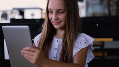 Çekici kız touchpad kullanarak ve gülümseyen katta oturan kulaklık