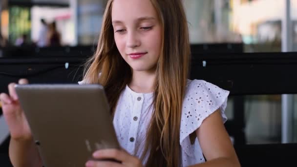 Jong meisje met behulp van en spelen op tablet-pc in café — Stockvideo