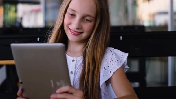 Chica joven usando la tableta PC en la cafetería y sonriendo — Vídeos de Stock