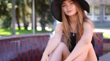 Sevimli sarışın kadın parkta bir bankta oturmuş