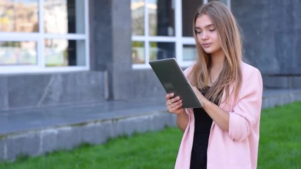 Genç sarışın tablet pc City üzerinde çalışıyor. Kadın sokakta kablosuz internet kullanarak. Mobil iletişim kavramı. — Stok video