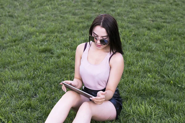 Parkta poz ve tablet tarama güzel Bayan