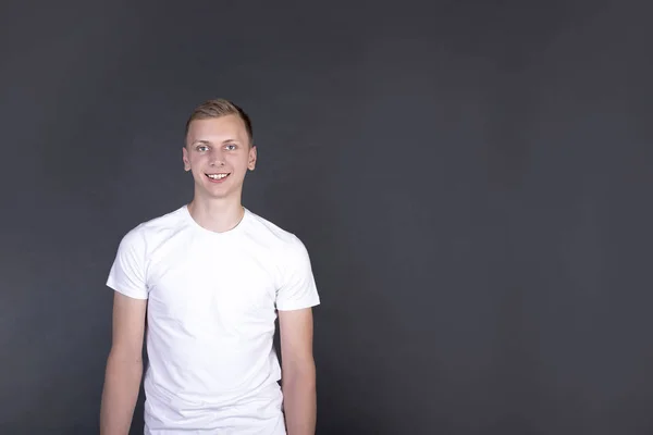 Mann steht und lächelt isoliert auf dunkelgrauem Hintergrund — Stockfoto