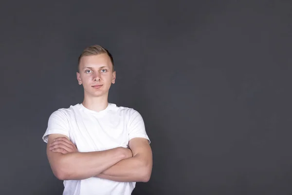 Blond handsome young man with hands crossed on chest looking in camera — Stock Photo, Image