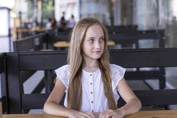 Beautiful blond model sitting alone at cafe — Stock Photo, Image