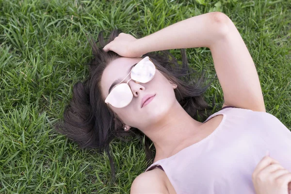 Brünette Dame ruht draußen auf Gras — Stockfoto