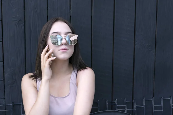 Lovely model enjoying smartphone talk in sunglasses — Stock Photo, Image