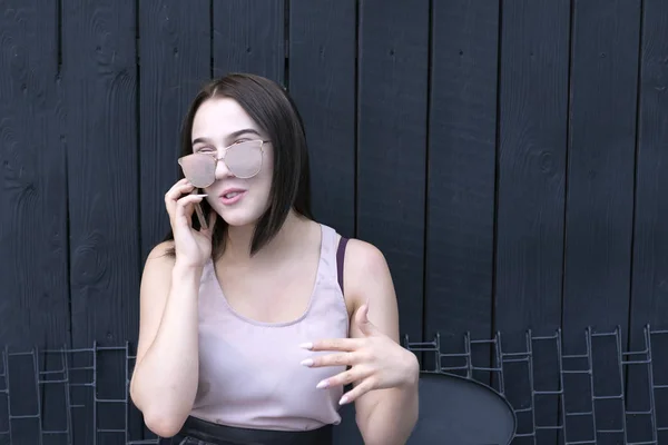 Chica disfrutando de teléfono inteligente hablar en gafas de sol —  Fotos de Stock