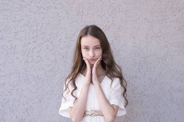 Esmer yüzü yakınındaki elleriyle