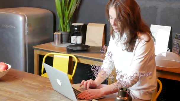 Jovem mulher usando laptop na cozinha — Vídeo de Stock