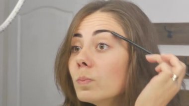 Kız kaş tarağı kullanıyor.