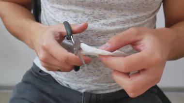 Yakın plan adam makasla kağıt kesiyor.