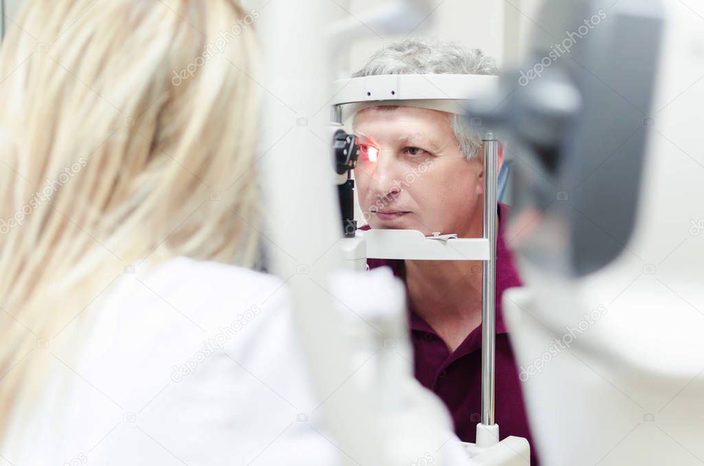 Refractometry. Keratometry. Refraction test. Optometry equipment. Man looking at refractometer eye test machine in ophthalmology, white empty screen