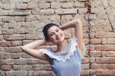 Mutlu ve gülümseyen kız Elleri başının arkasında poz.