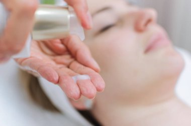 Masör el sıvı cilt bakımı için güzellik spa salonu güzel genç kadın, yakın çekim.
