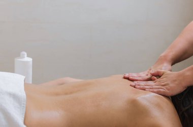 Genç kadının güzellik spa salonunda geri masaj losyonu krem uygulayarak masör.
