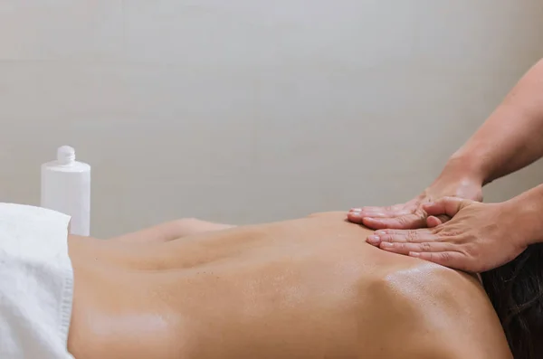 Massör Tillämpa Massage Lotion Grädde Ung Kvinnas Tillbaka Spa Skönhetssalong — Stockfoto