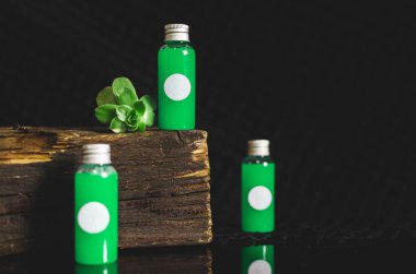 küçük dolu cam şişe yeşil sıvı ve beyaz boşluk ile siyah arka plan, tıp kavramı, çok önden görünüm