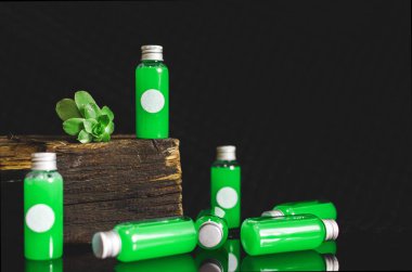 çok yeşil sıvı ve siyah arka plan, tıp kavramı, kozmetik ürünleri, beyaz boşluk ile önden görünümü küçük dolu cam şişe