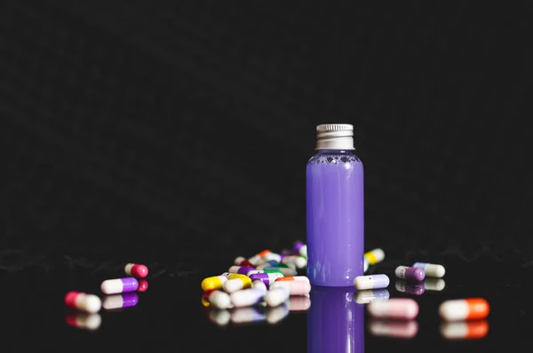 黒の背景 医学概念 錠剤に紫の液体と小さな杯バイアルの正面 — ストック写真