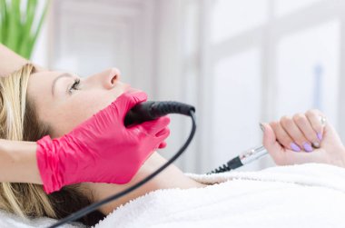 Donanım kozmetik. Genç kadın bir güzellik salonu yordam kaldırma Radyofrekans getting portresi kapatın.