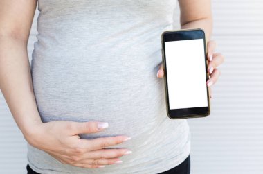 Holding ve cep telefonu boş ekran ile gösterilen hamile kadının fotoğrafını kapatın.