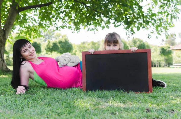 Vacker Gravid Kvinna Liggande Park Med Dottern Som Innehar Tom — Stockfoto