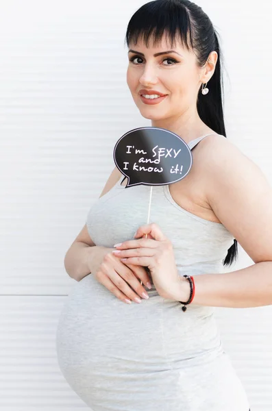 Schöne Junge Schwangere Frau Lächelt Und Hält Ein Lustiges Standrequisit — Stockfoto
