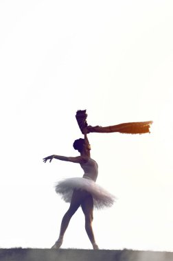 Gün batımı poz güzel genç balerin dikey görüntü dışarıda ellerini eşarp ile.