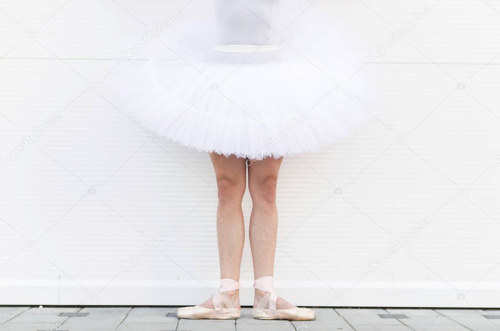 Close up of ballerina's legs, dancer standing in first position of classic ballet.