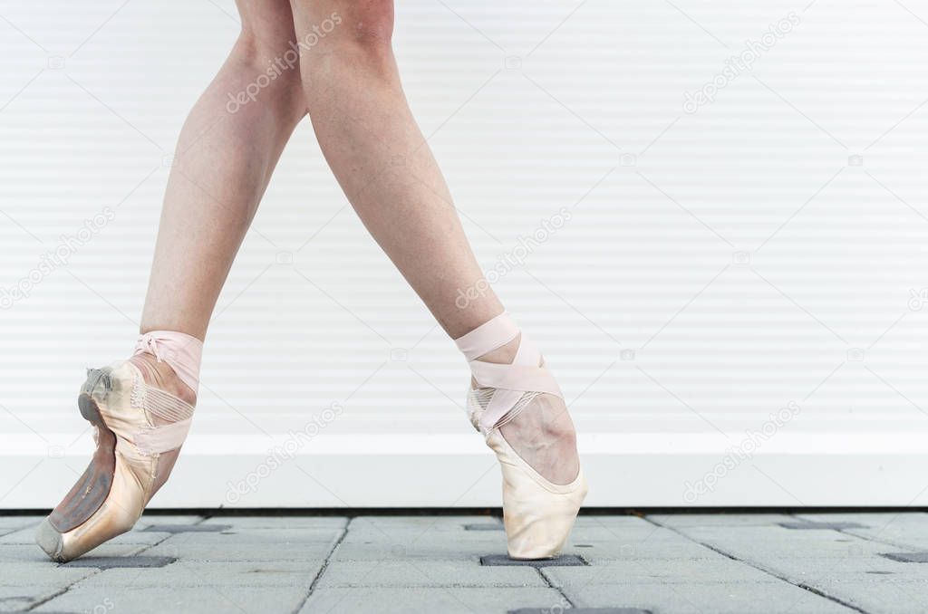 Legs of ballerina in ballet shoes, close up.