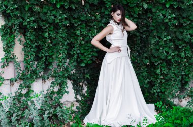 Güzel genç model dışında uzun beyaz elbiseli, metin için yer poz.