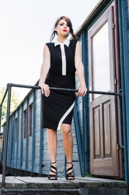 Bir trenin terasta zarif siyah elbiseli poz güzel genç kadın.