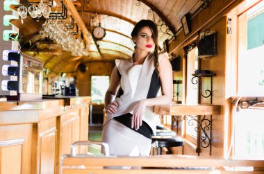 Genç güzel kadın model içinde caffe bar zarif giysiler giyiyor, poz.