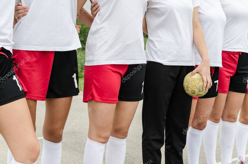Cropped image of young female handball players standing on court.